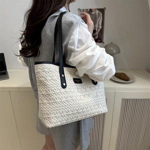 Chic white lace tote bag with black leather straps and gold branding for summer style