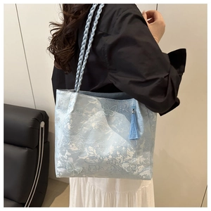 Close-up of light blue lace tote bag with floral patterns and 3D butterfly appliques