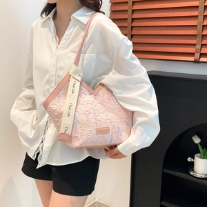 Sac bandoulière rose matelassé avec broderies colorées et large bandoulière logo