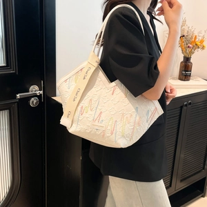 Sac fourre-tout blanc texturé avec broderie colorée et bandoulière pour l'été 2025