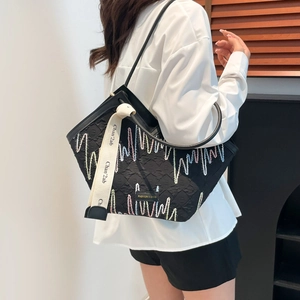 Sac sous le bras matelassé noir avec coutures colorées et large bandoulière décorative