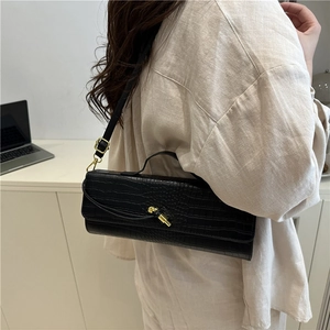 Minimalist black crocodile embossed baguette bag with gold buckle on shoulder