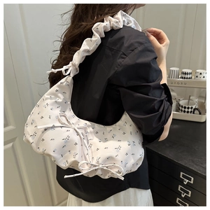 Detailed view of floral pleated shoulder bag with blue patterns and cute bow ties