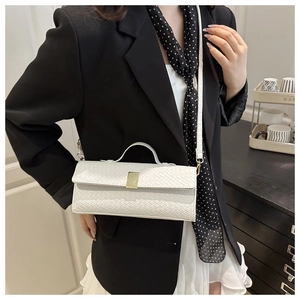 Detail of white woven texture shoulder bag with gold clasp and elegant handle