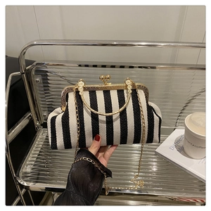 Détail du sac à main vintage à rayures noires et blanches avec fermoir doré et chaîne