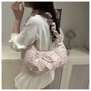 Floral canvas shoulder bag featuring a decorative bow and pleated strap detail