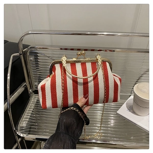 Détail d'un sac vintage à rayures rouges et blanches avec cadre doré et chaîne