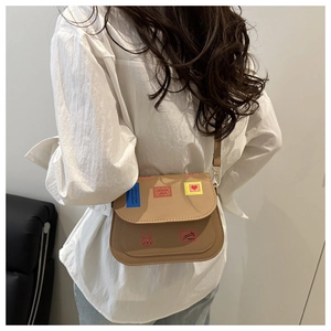 Detailed view of khaki square crossbody bag featuring a cute bunny and heart design