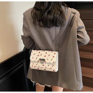 Sac bandoulière chic en cuir crème avec imprimés cerises et bandoulière chaîne argent