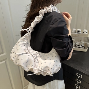 Floral shoulder bag with bow detail and ruched strap shown on model for casual wear