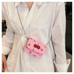 Dettaglio borsa a tracolla rosa con stampe di ciliegie e chiusura con strass brillanti