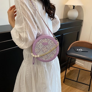 Chic purple round crossbody bag with geometric weaving and pearl chain strap on model