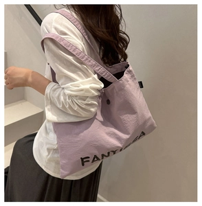 Close-up of light purple tote bag featuring FANYISSA lettering and nylon texture