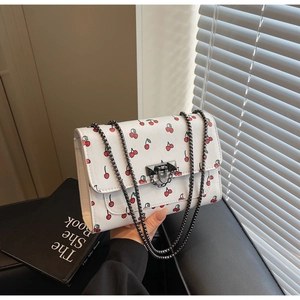 Détail du sac carré en cuir blanc à imprimé cerise avec chaîne et boucle métal