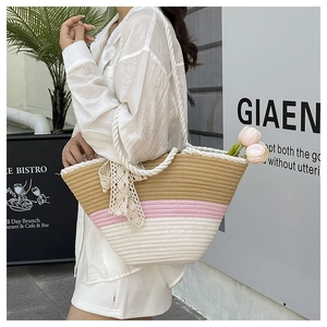 Close-up of tricolor straw tote bag with rope handles and white lace bow detail