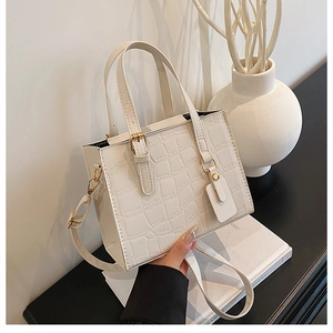 Close-up of cream crocodile pattern tote bag with golden hardware and adjustable strap