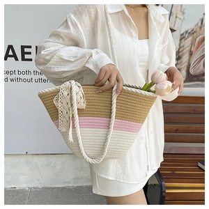 Detail of three-tone woven bucket bag featuring cotton rope handles and lace bow accent