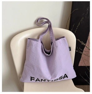 Detail of light purple canvas tote with brand logo and secure metal snap closure