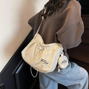 Große beige Umhängetasche mit Kordelzug und passender runder Münztasche an der Schulter