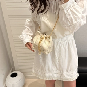 Minimalist straw bucket bag with green floral embroidery and pearl chain strap