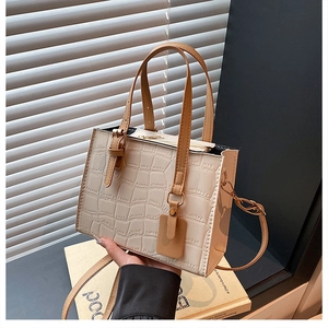 Detail of cream faux crocodile texture leather handbag with light brown handles