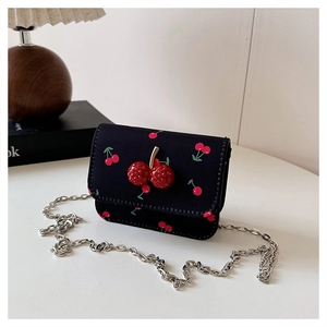 Detail einer schwarzen Kettentasche mit Kirschprint und 3D-Strass-Kirschschnalle