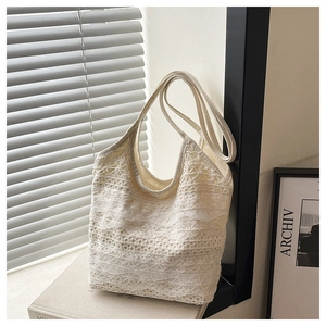 Close-up of white lace tote bag with layered hollow mesh design and wide strap