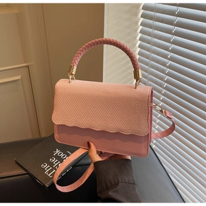 Détail du sac sous le bras rose avec rabat tissé et accents de bords ondulés