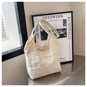 Nahaufnahme der weißen Schultertasche aus Spitze mit feiner Blumenstickerei und Textur