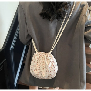 Detail view of floral drawstring bucket bag with pink flower pattern and cord straps