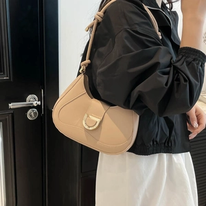 Minimalist beige leather shoulder bag with gold D-ring buckle and knotted strap
