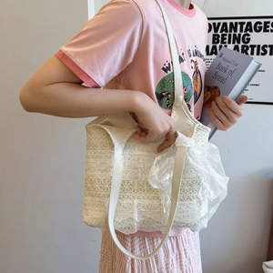 Off-white lace tote bag with floral patterns and side bows for beach vacations