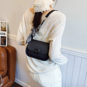 Black mini crossbody bag with a matte finish, chain strap and striped silk scarf decor