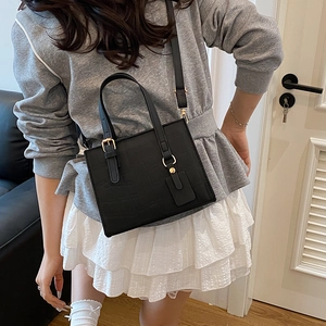 Chic black crocodile embossed crossbody bag for women with gold hardware and top handle