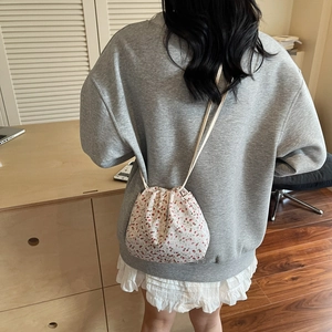 Floral drawstring bucket bag with pink flower pattern and slim strap for casual wear