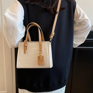 Minimalist cream crocodile embossed crossbody bag with brown handles and shoulder strap