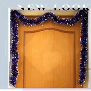 Detail of red blue and silver tinsel garland with stars hanging on a wooden door