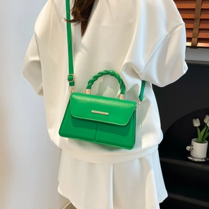 Sac bandoulière vert avec poignée tressée sur un sweat blanc vue de dos