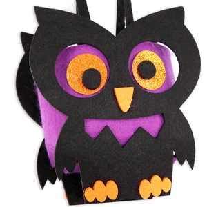 Detail of owl-shaped felt Halloween candy bag with purple accents and orange glitter eyes