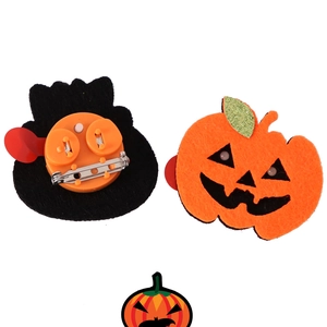 Front and back detail of glowing Halloween pumpkin pins with LED lights and safety pins