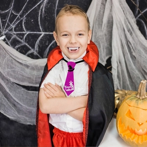 Detail of purple sequin Halloween tie with ghost pattern on a child's vampire costume