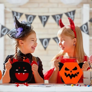 Kids carrying cartoon pumpkin and bat felt candy bags in a festive Halloween room