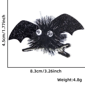 Black glittery bat wing hair clip with pom-poms and googly eyes for Halloween costumes