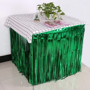 Detail of green metallic fringe table skirt with shiny tinsel texture for party decor
