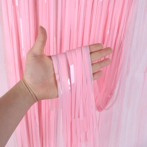 Close-up of pink tinsel curtain showing the glossy metallic foil texture and dense fringe