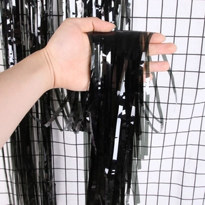 Detailed close-up of glossy black fringe curtain material for party background decor
