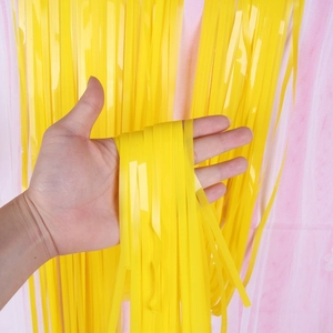 Detail of lightweight bright yellow macaron fringe curtain for party backdrop decoration