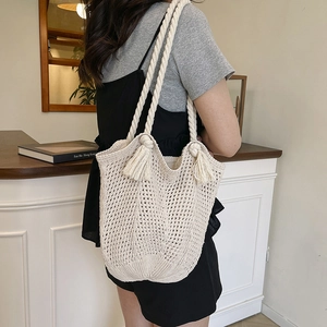 Chic beige crochet tote bag with woven mesh texture and decorative cotton rope tassels
