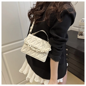 Détail du sac bandoulière blanc matelassé avec chaîne épaisse et sangle ajustable