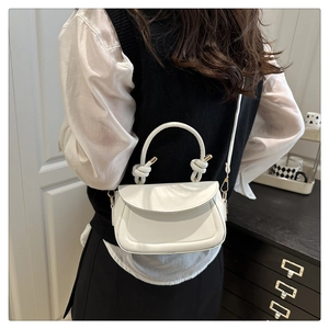 Chic white PU leather crossbody bag with knotted handle detail shown on female model